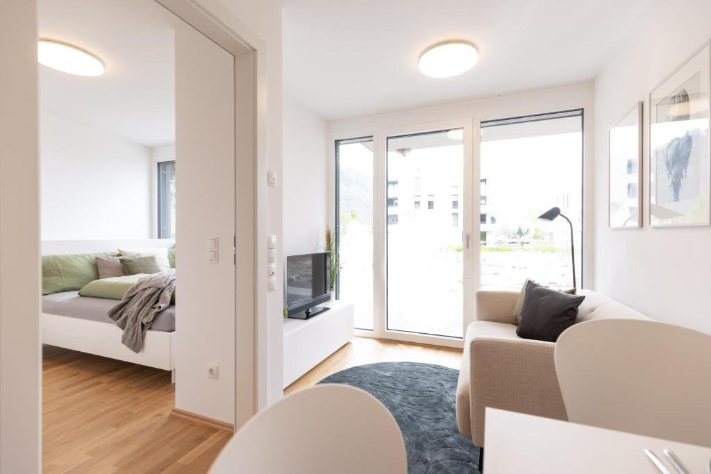 多恩比恩Smart Living Dornbirn的带沙发和电视的白色客厅
