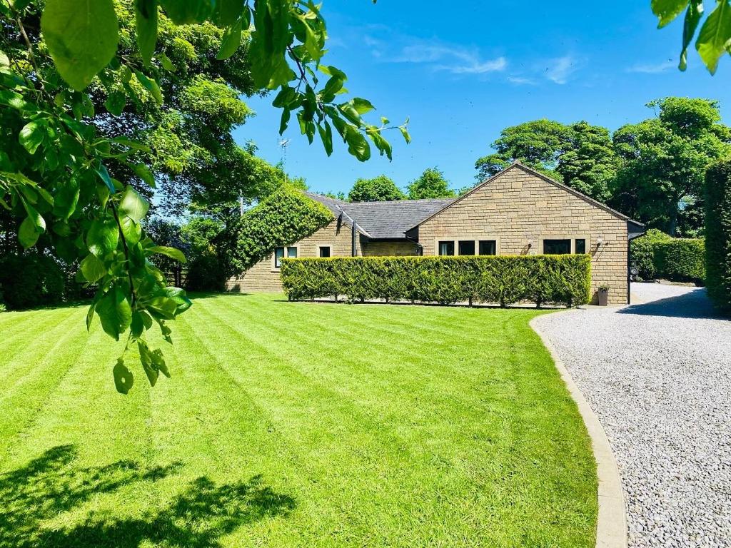 沃利Calder Cottage in The Ribble Valley的前面有大草坪的房子