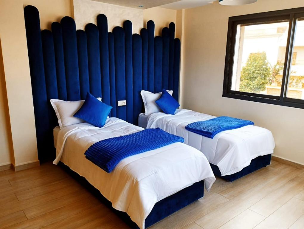 萨菲Incantevole villa Safi Sidi Bouzid near beach的两张带蓝色枕头的床