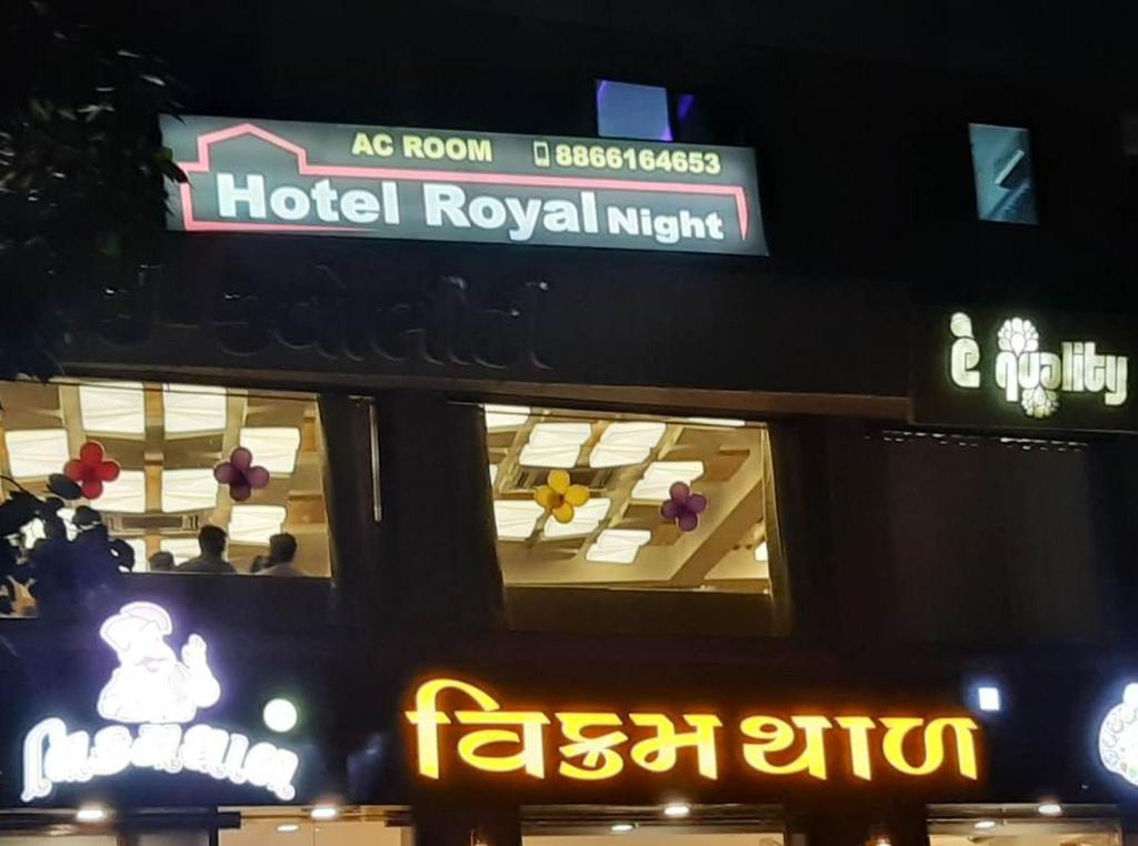 艾哈迈达巴德hotel royal night的建筑上标有酒店皇家夜间标志