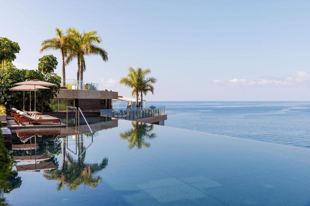 卡列塔Saccharum - Resort and Spa - Savoy Signature的毗邻大海的棕榈树游泳池