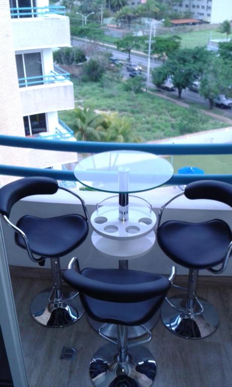 波拉马尔Apartamento Deluxe Isla Margarita - Costa Azul的窗前的一张桌子和四把椅子