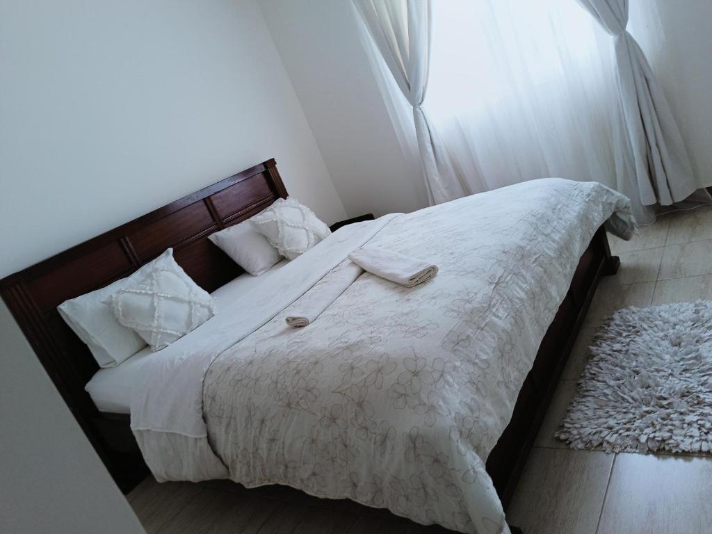 Langata RongaiHome away的一间卧室配有一张带白色床单的床和一扇窗户。