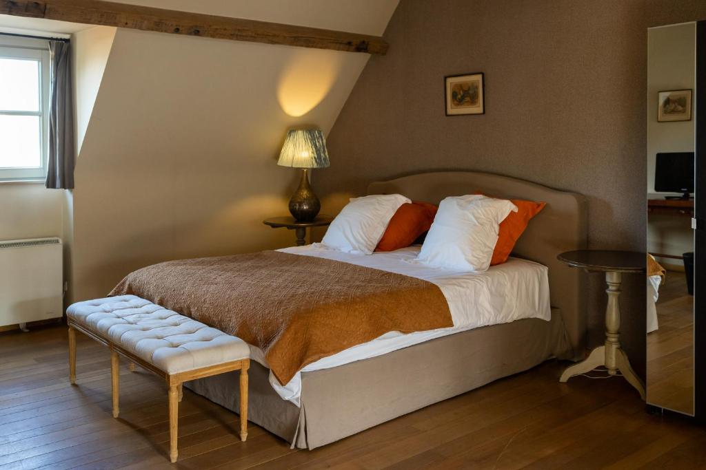 达默Het Oud Gemeentehuis-De Levensboom的一间卧室配有一张床、一张桌子和一盏灯