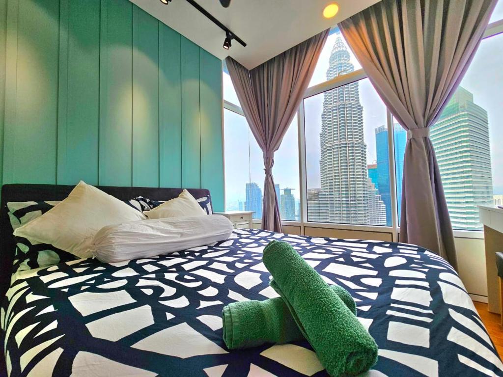 吉隆坡De Sky Suites KLCC Kuala Lumpur的卧室设有一张绿色和白色的床,配有大窗户