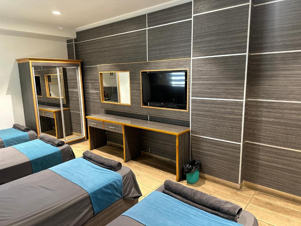 亚喀巴ArwaHotel Apartments اروى للشقق الفندقية的酒店客房设有两张床和电视。