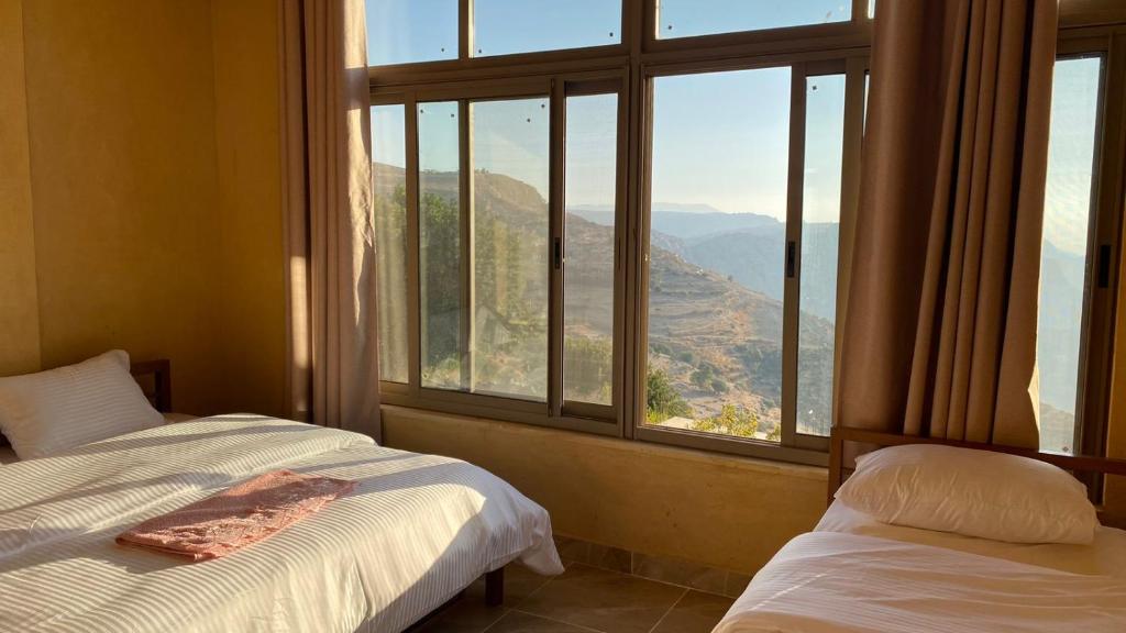 达纳Wild Dana Eco Lodge- Hotel-Eco-Camp的一间卧室设有两张床和大窗户