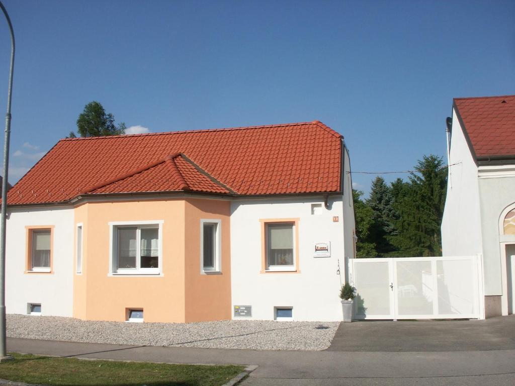 MarcheggGästehaus Bett-i的白色和橙色的房屋,有红色屋顶