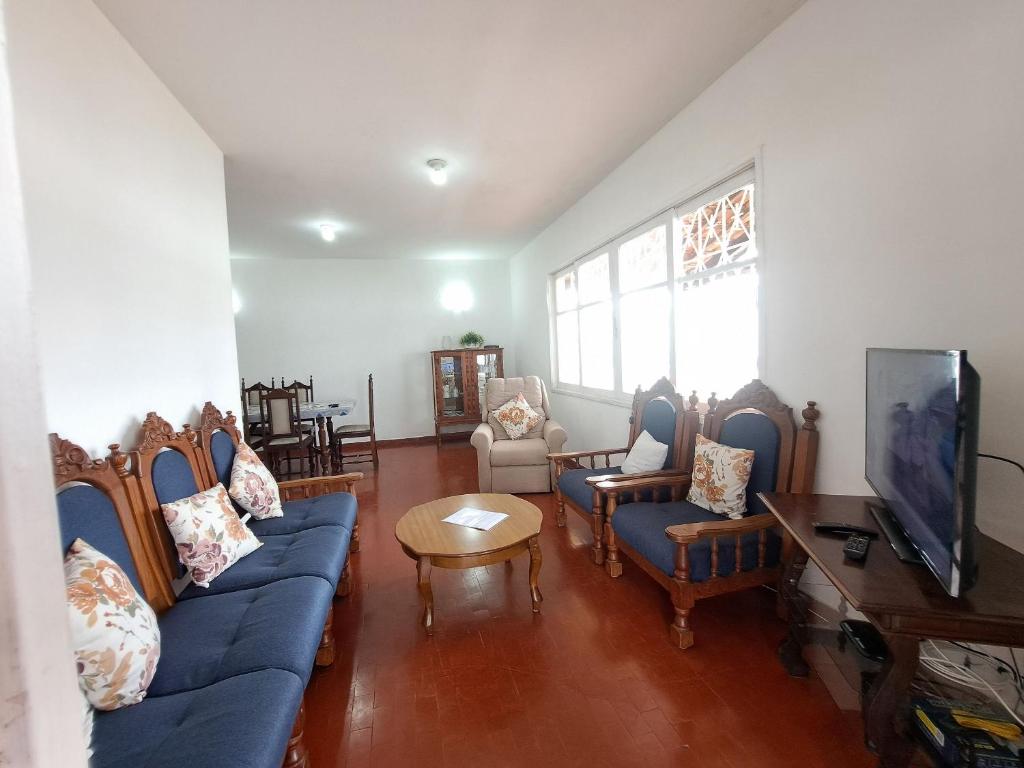 卡波布里奥3 QTS Churrasqueira Garagem perto do Forte e Ilha do Japonês的客厅配有蓝色的沙发和电视