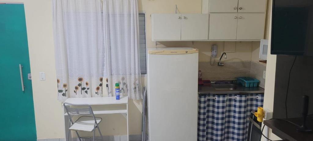 贝洛奥里藏特Kitinet Central的小厨房配有白色橱柜和水槽
