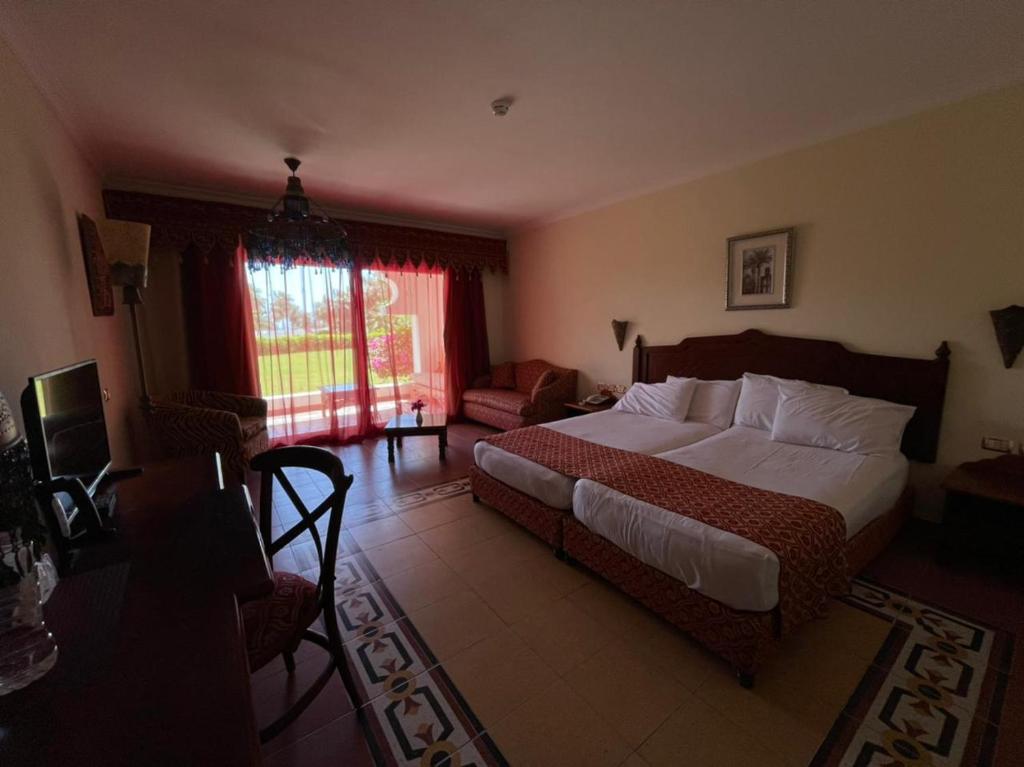 沙姆沙伊赫Harem at Coral Bay的一间带大床的卧室和一间客厅