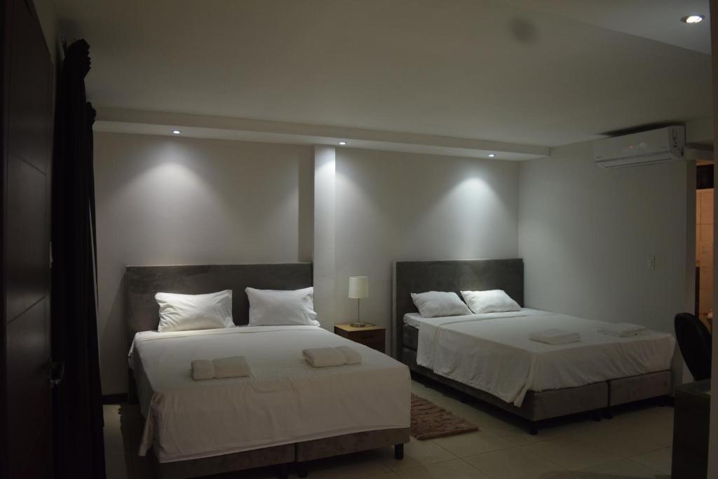 帕拉马里博Hotel RITZZ的一间卧室配有两张带白色床单的床