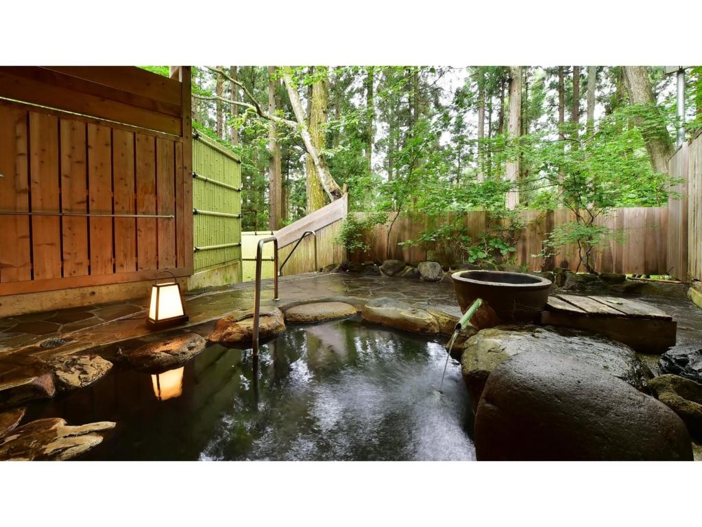 YokokuraOyado Kotobuki - Vacation STAY 97600v的后院设有带卫生间和围栏的池塘