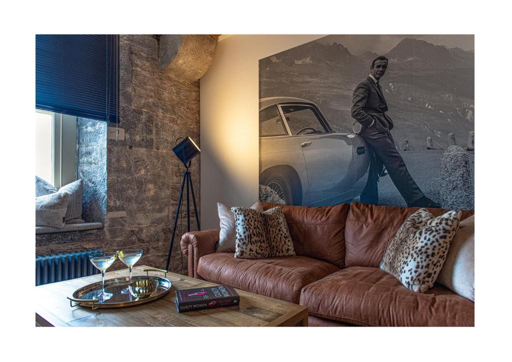 普里茅斯RWY Suite007 Luxury Signature Apartment with sea view的客厅配有沙发和一张男人的照片