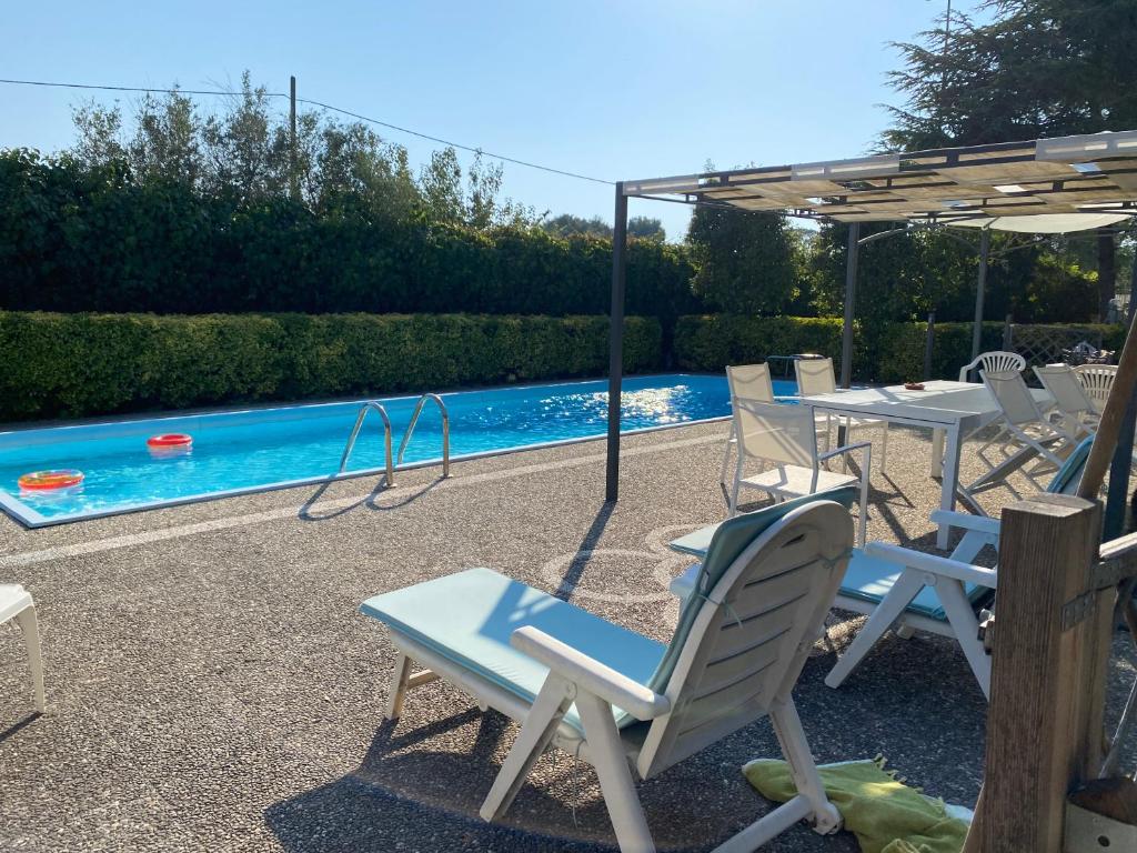 莱切Villa Margherita的一组椅子和一个带秋千的游泳池