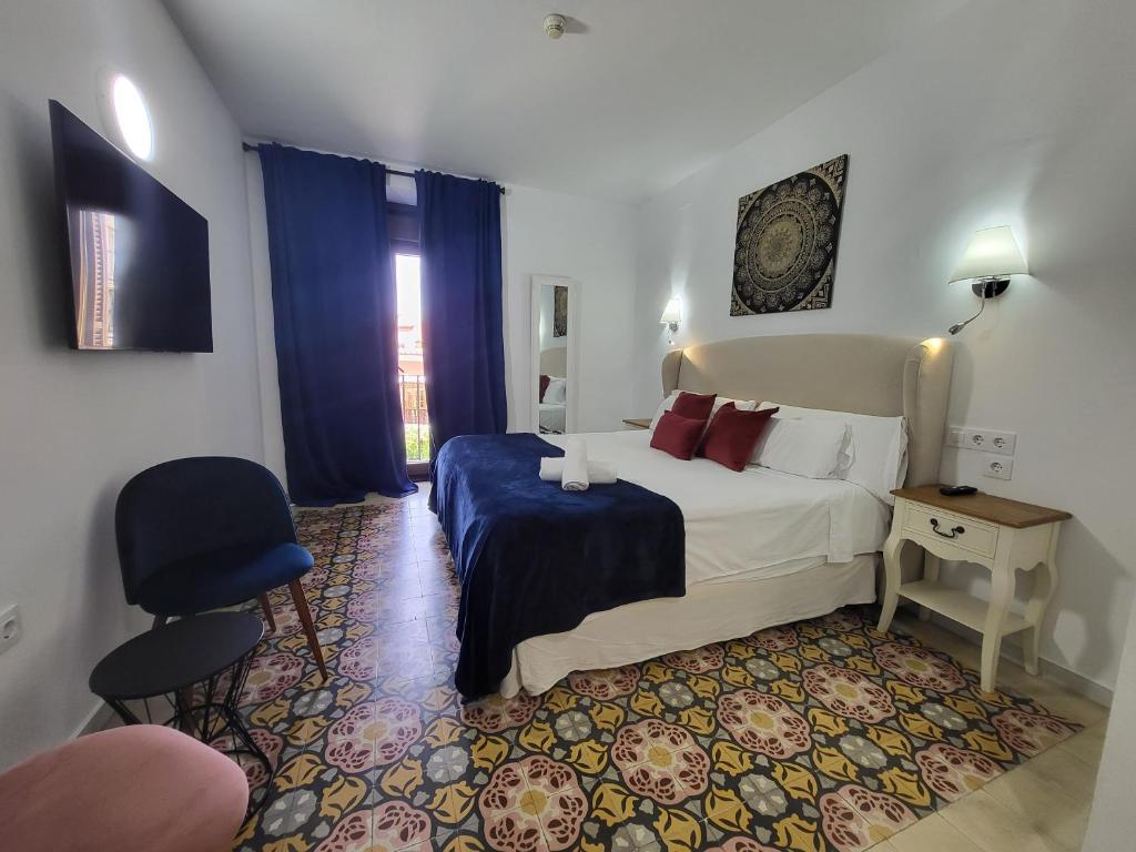 塞维利亚Casona de San Andrés的配有一张床和一把椅子的酒店客房