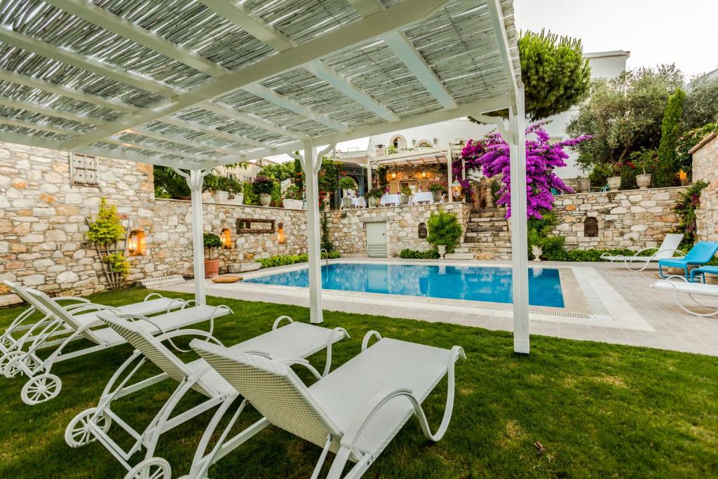 切什梅艾佩尤尔旅馆的一个带白色椅子的庭院和一个游泳池