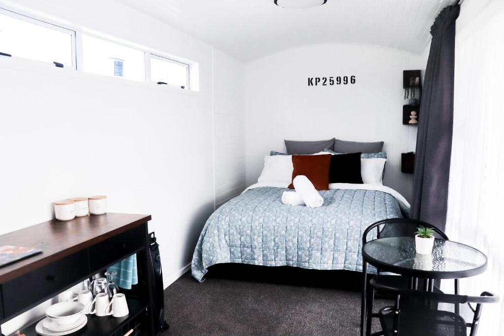 达格维尔Rustic Rails Accommodation的一间小卧室,配有一张床和一张桌子