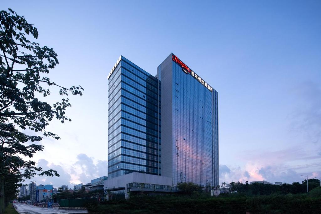 增城广州新塘希尔顿欢朋酒店的一座高大的建筑,上面有标志