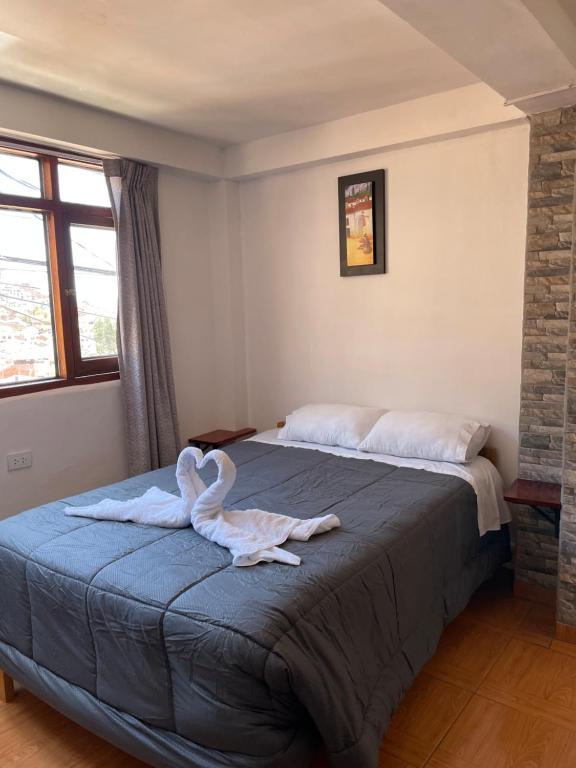 库斯科Big Vacation Hostel的一间卧室配有一张床铺,床上铺有天鹅毛巾