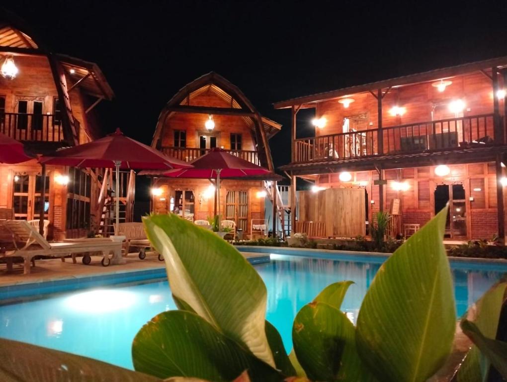 艾湄湾Room 3, Agung Guesthouse at Melasti Mountain Villas, Amed的夜间带游泳池的度假村