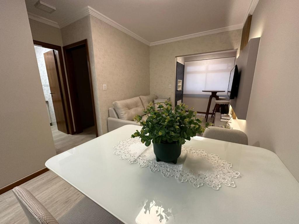 卡庞达卡诺阿Apto super luxo beira mar Capão da Canoa的客厅里一张带盆栽植物的白色桌子