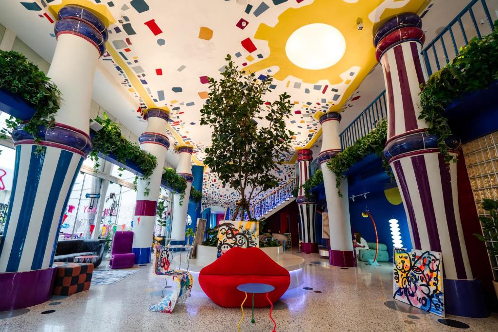 曼谷The Fig Lobby的建筑里带柱子和红色椅子的走廊
