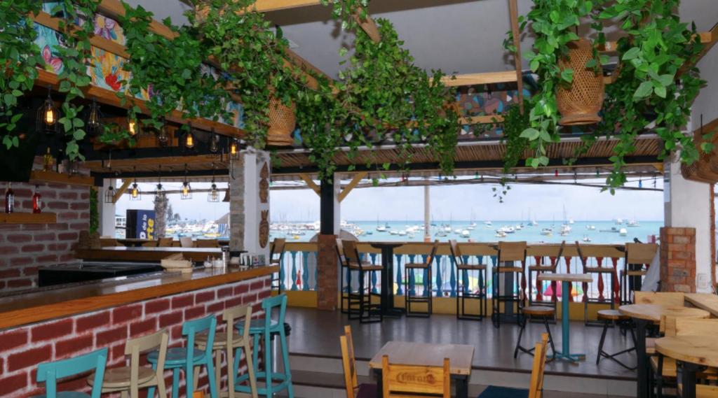 萨利纳斯Chescos Hotel & Hostel的一间带桌椅的海景餐厅