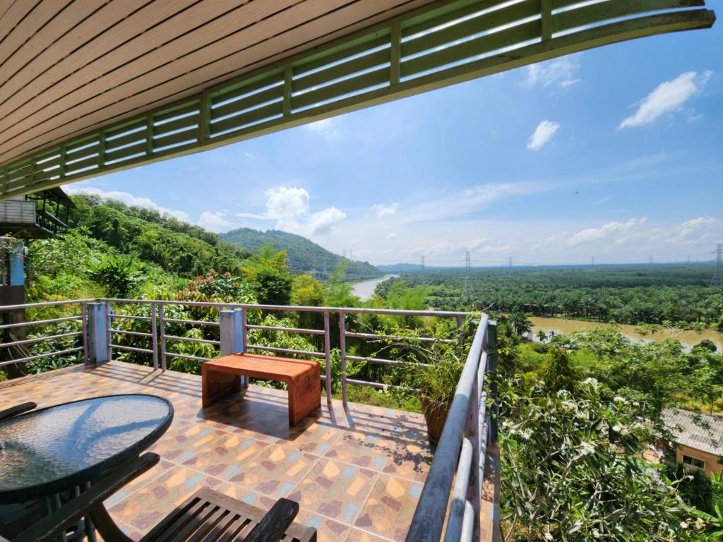 素叻Baan Khao Noi Resort的房屋的甲板上设有桌椅,享有风景。