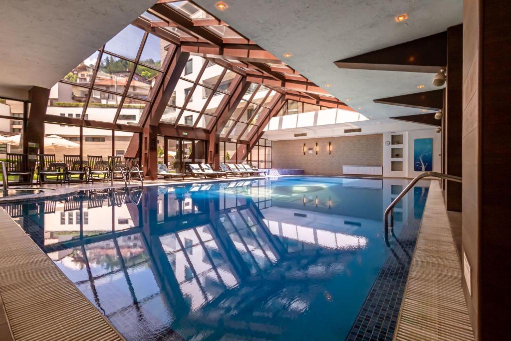 代温帕森克温泉酒店的一个带玻璃天花板的大型游泳池