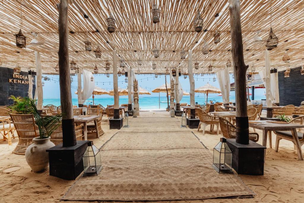 蓝梦岛Indiana Kenanga Boutique Hotel & Spa的海滩上的餐厅,配有桌椅