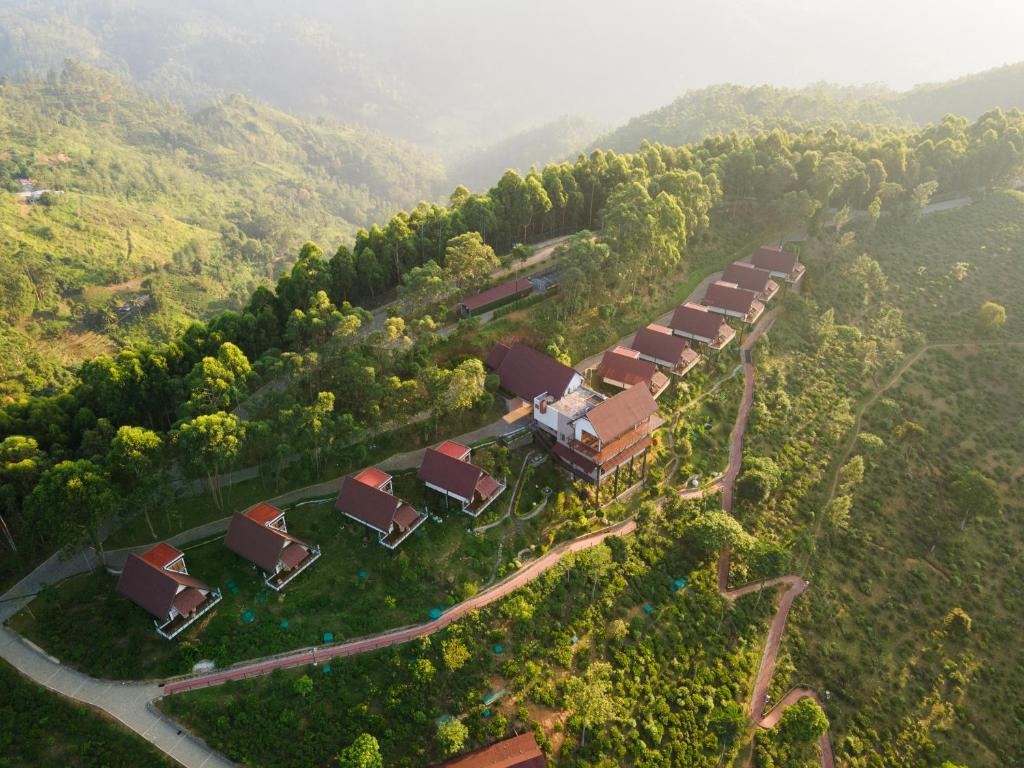埃拉Anasa Wellness Resort的享有拥有房屋和树木的农场的空中景致