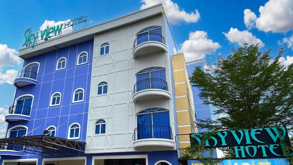 巴淡岛中心Sky View Hotel Managed by OS的蓝色的建筑,前面有标志