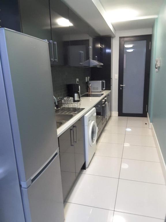 温特和克City View Unit 130 at 77 on Independence的厨房配有冰箱和洗衣机。