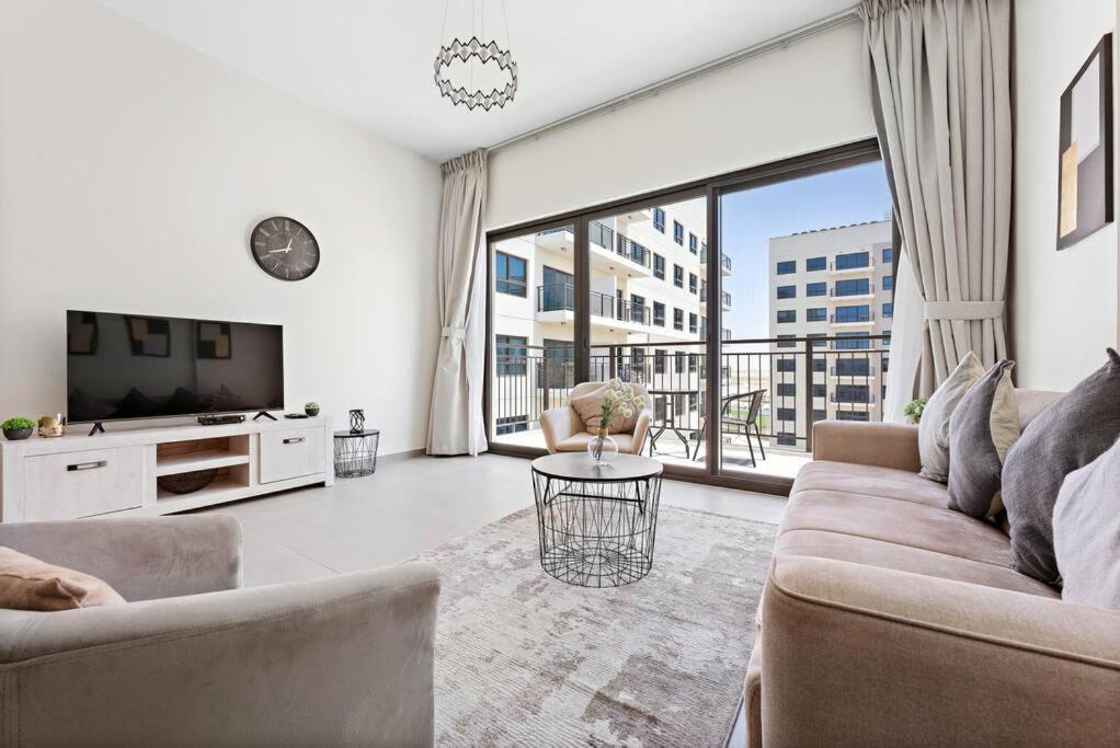 迪拜StoneTree - Spacious 2BR Apartment in Golf Views Block A的带沙发和电视的客厅
