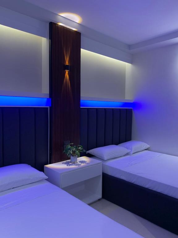 巴科洛德Central Block Inn的蓝色灯的客房内的两张床