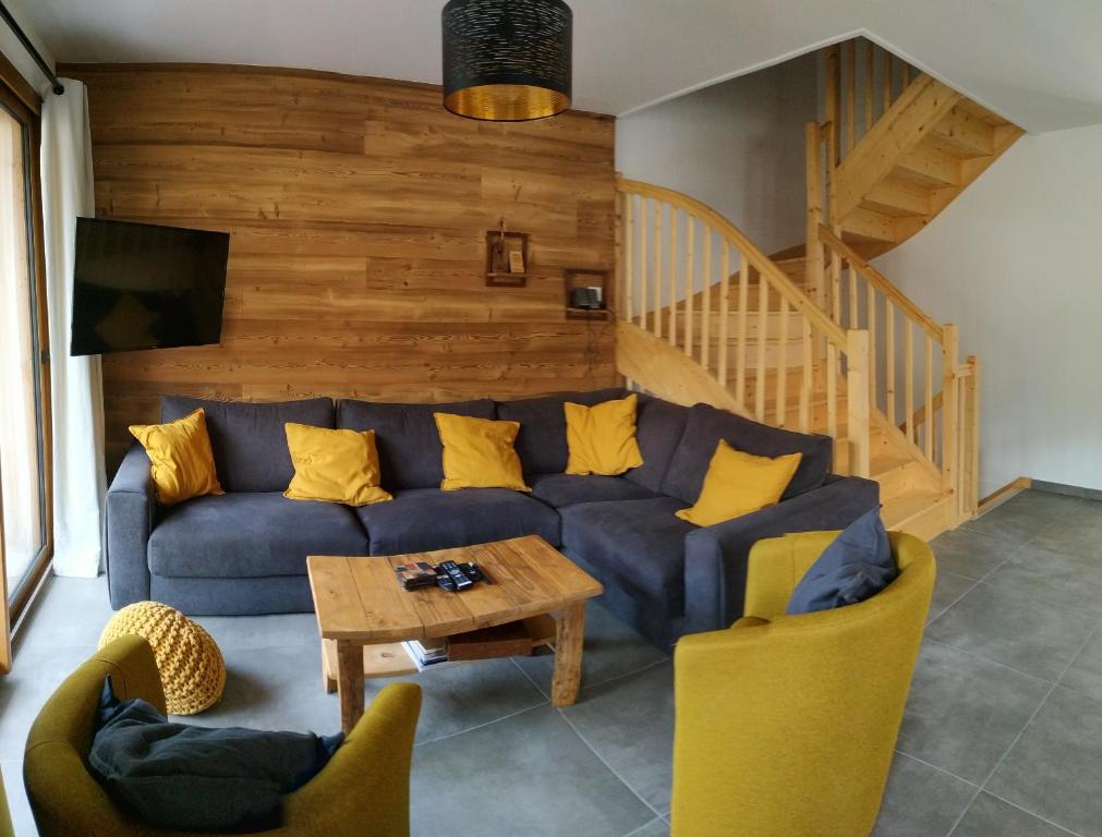 莫尔济讷Chalet Rivendell, Morzine sleeps 10 with garage的客厅配有蓝色的沙发和黄色的枕头。