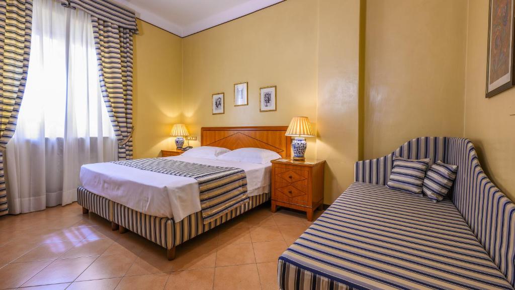 雷焦艾米利亚艾尔伯格瑞吉欧酒店的配有一张床和一把椅子的酒店客房