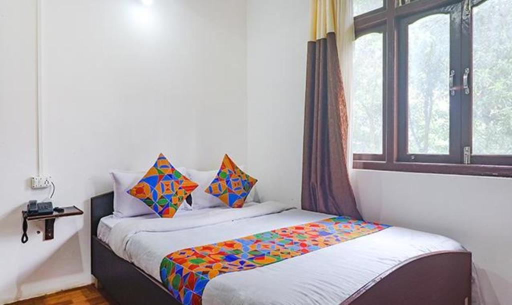 甘托克FabExpress Laxmi Niwas的一间小卧室,配有一张带窗户的床
