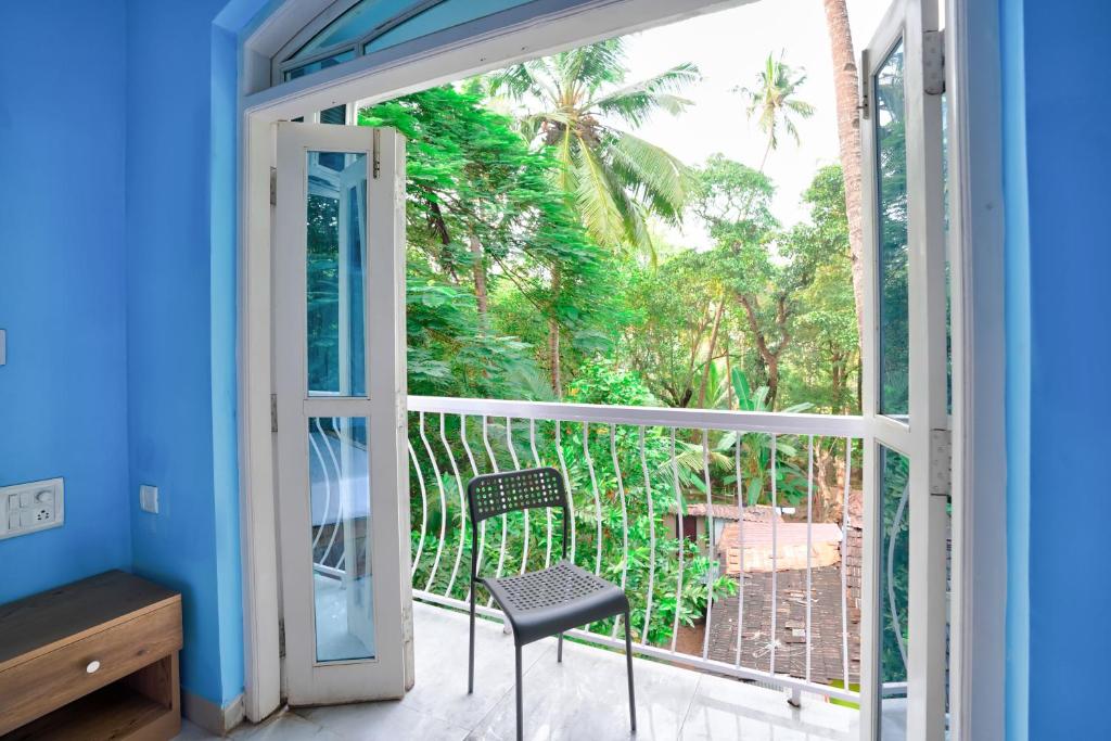 卡兰古特Calangute By Goa Journey的一间设有一扇门的客房,可通往一个带椅子的阳台