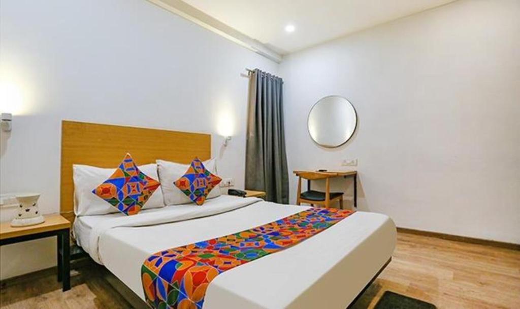 新德里FabHotel Urban Residency的配有一张大床和镜子的酒店客房