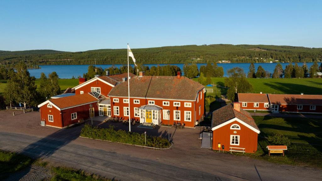 VallstaSTF Undersvik Gårdshotell & Vandrarhem的享有湖景的大型红色房屋的空中景致