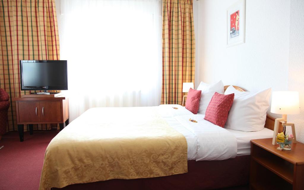 明斯特艾玛迪斯城市酒店的酒店客房,配有床和电视