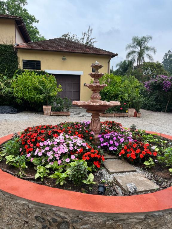 圣罗克Vila Adega Maravilha的一座花园,房子前面有一个喷泉