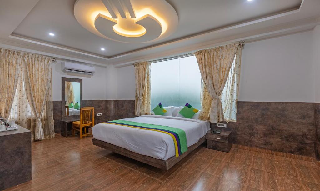 马迪凯里Treebo Trend Siri Ambari Resorts的一间卧室配有一张大床和吊扇