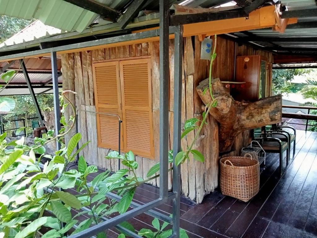 北碧Casa Bonita Kanchanaburi的小木屋设有门廊,配有桌椅