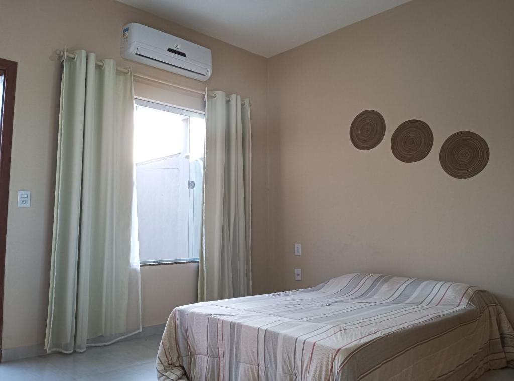 圣马特乌斯Casa - Luxo e Conforto, Hidromassagem a 50m do Mar的一间卧室配有一张床,窗户配有空调