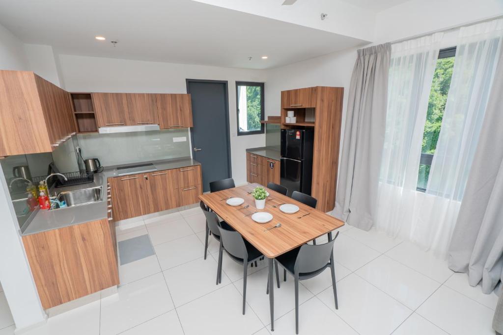 淡文Ipoh Tambun Sunway Onsen Suite 3R2B Maya的厨房以及带木桌和椅子的用餐室。