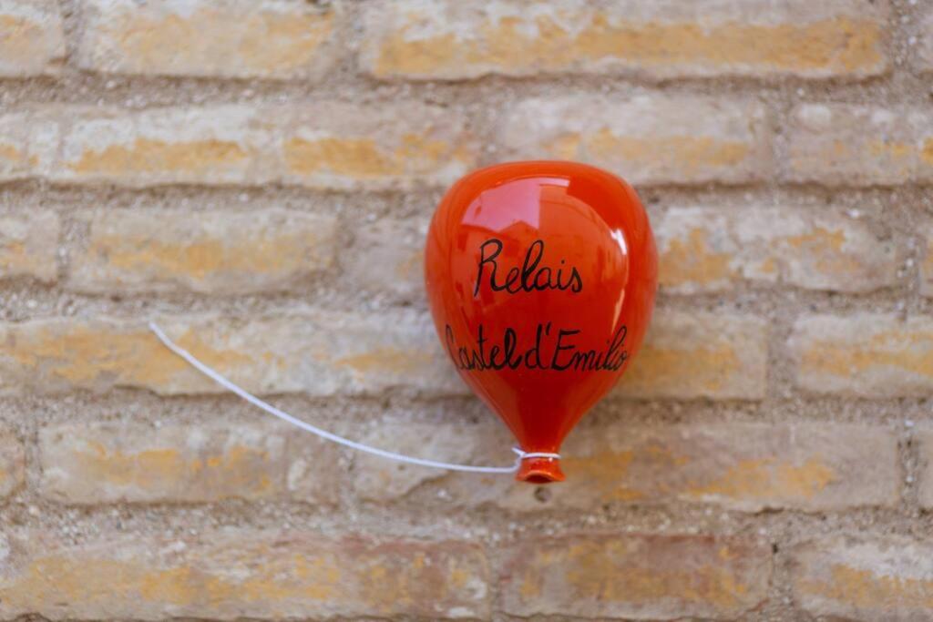 CasseroRelais Castel d'Emilio – Casa ARANCIO的橙色气球附在砖墙上