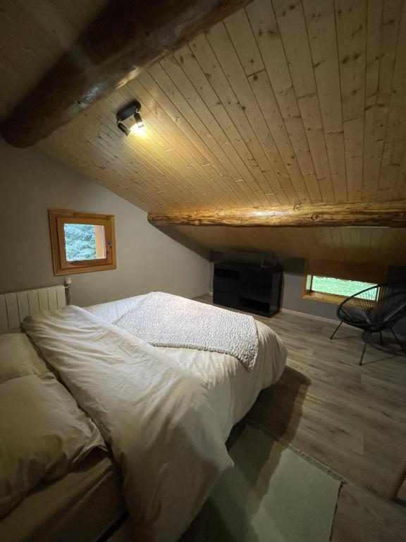LevassaixAppartement Chalet Petzu - 6 Pers - Parking - Ski au pied的木天花板的客房内的一张床位